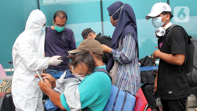 Petugas medis (kiri) melakukan rapid test antigen terhadap calon penumpang di Terminal 2 Bandara Soekarno-Hatta, Tangerang, Banten, Selasa (22/12/2020). Calon penumpang mengaku rata-rata antre hingga tiga jam untuk mendapatkan layanan rapid test antigen. (merdeka.com/Arie Basuki)