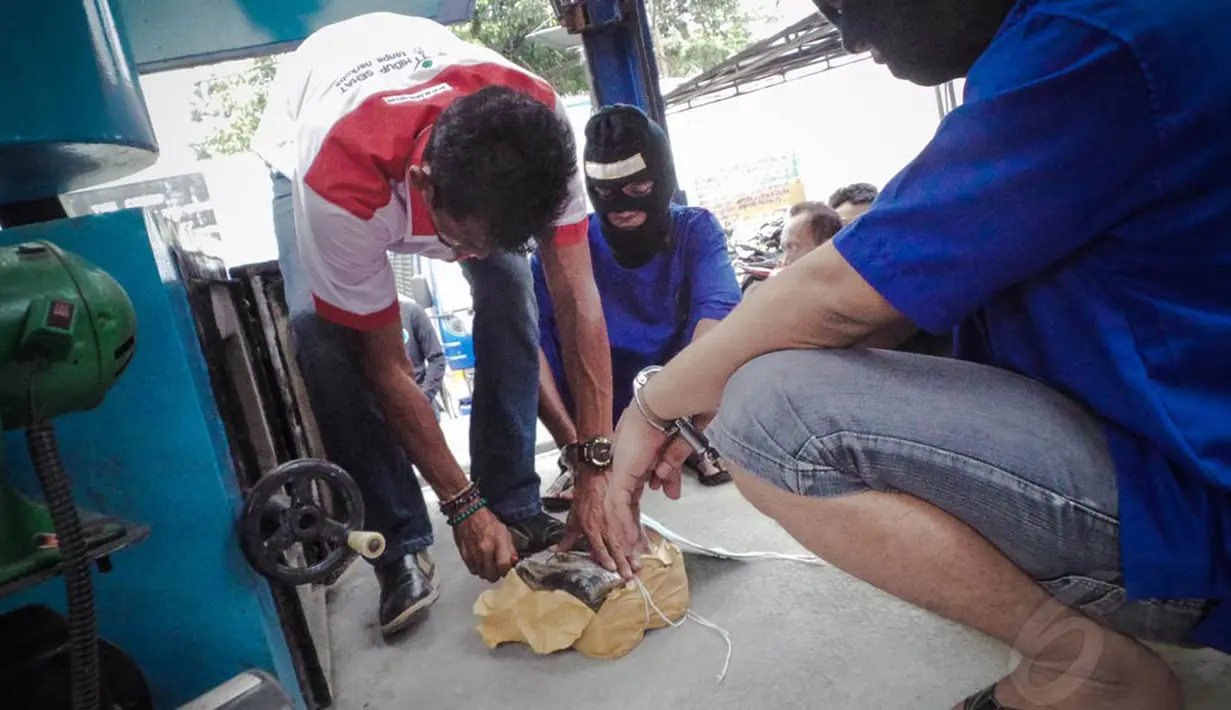 Petugas saat akan memasukkan barang bukti ke dalam mesin penghancur di halaman Gedung BNN, Kamis (14/8/14). (Liputan6.com/Faizal Fanani)