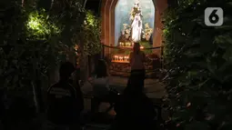 Jemaat umat kristiani melaksanakan Malam Misa Natal di Gereja Katedral Santo Petrus Bandung, Jawa Barat, Kamis (24/12/2020). Pohon Natal setinggi 16 meter yang selalu hadir menghiasi halaman gereja menjelang Hari Raya Natal ditiadakan. (Liputan6.com/Herman Zakharia)