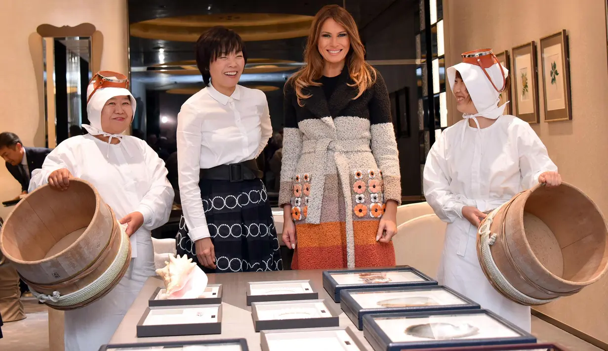Ibu Negara AS Melania Trump (kedua kanan) didampingi Istri PM Jepang,  Akie Abe (ketiga kanan) tersenyum saat mengunjungi toko pembuat perhiasan mutiara Jepang di distrik Ginza, Tokyo (5/11). (AFP Photo/Pool/Katsumi Kasahara)