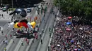 Di sepanjang jalan, warga antusias meyambut meriah parade beragam balon karakter kartun fiksi dan film animasi. (RODRIGO ARANGUA/AFP)