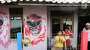 Warga berdiri di depan pintu rumah dengan warna-warni cat dinding dan grafiti di Kampung Bekelir, Babakan Kota Tangerang, Jumat (16/11). Kampung ini dihuni sekitar 300 KK. (Liputan6.com/Fery Pradolo)