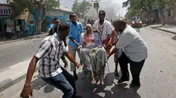 Seorang pria terkena serangan bom mobil di Mogadishu, Somalia, Senin (13/3). Sebuah mobil meledak di dekat Hotel Weheliye dan menewaskan sejumlah orang. (AP Photo / Farah Abdi Warsameh)