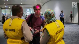 Petugas Kesehatan Karantina Bandara (KKB) memeriksa suhu badan penumpang yang baru mendarat di Terminal 3 Bandara Soetta, Tangerang, Rabu (15/5/2019). Pemeriksaan ini setelah ditemukan kasus wisatawan Afrika yang mengidap cacar monyet di Singapura beberapa waktu lalu. (Liputan6.com/Faizal Fanani)