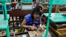 Seorang pekerja menggulung cerutu di sebuah pabrik di Havana, Kuba, Kamis (1/3). (ADALBERTO ROQUE/STR/AFP)