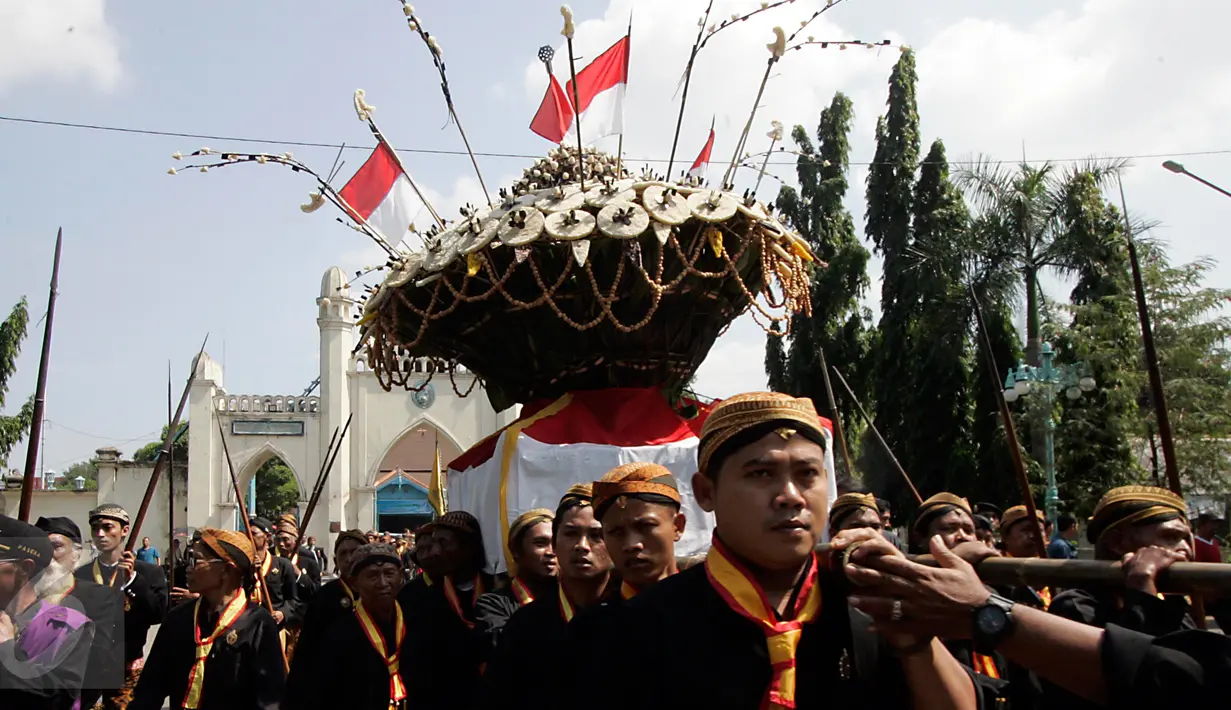 Para abdi dalem Keraton membawa sesaji gunungan pada acara Grebeg Syawal di halaman Masjid Agung Solo, Jawa Tengah, Jumat (8/7). Grebeg Syawal merupakan tradisi Keraton Kasunanan Surakarta untuk merayakan Idul Fitri. (Liputan6.com/Boy Harjanto)