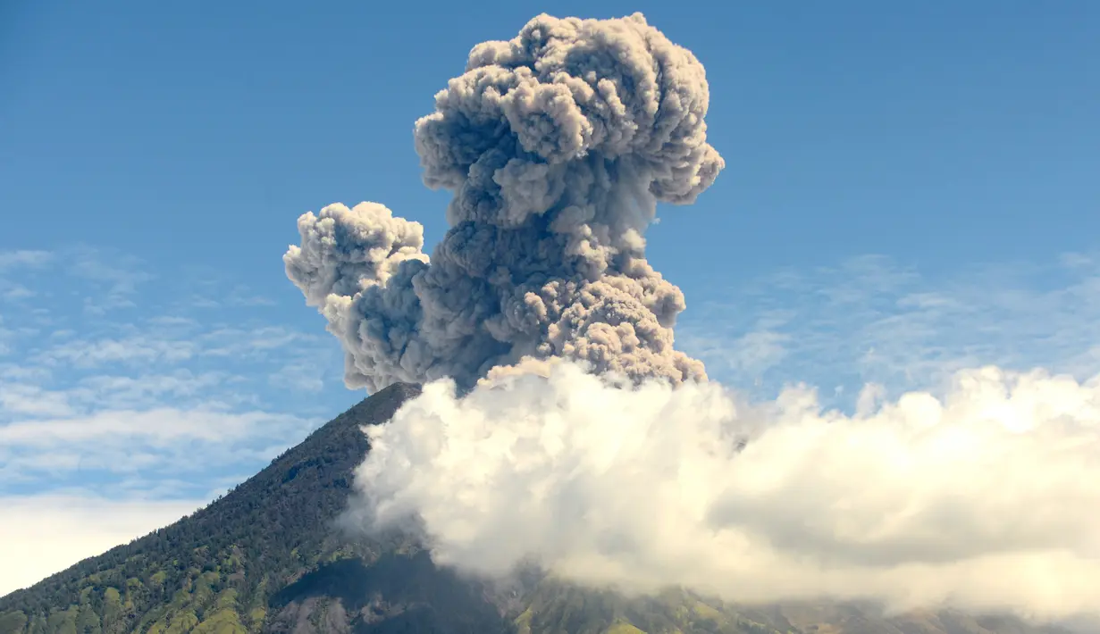 Pemandangan semburan abu vulkanik Gunung Agung dari Kecamatan Kubu, Kabupaten Karangasem, Bali, Jumat (6/7). Semburan abu tersebut tidak berdampak pada kunjungan wisatawan. (AFP FOTO / Sonny Tumbelaka)