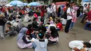 Pengunjung menikmati makan sambil lesehan jelang Closing Ceremony Asian Games 2018 di kawasan Gelora Bung Karno, Jakarta, Minggu (2/9). Mereka tidak mendapatkan kursi makan karena dipadati pengunjung. (Liputan6.com/Fery Pradolo)