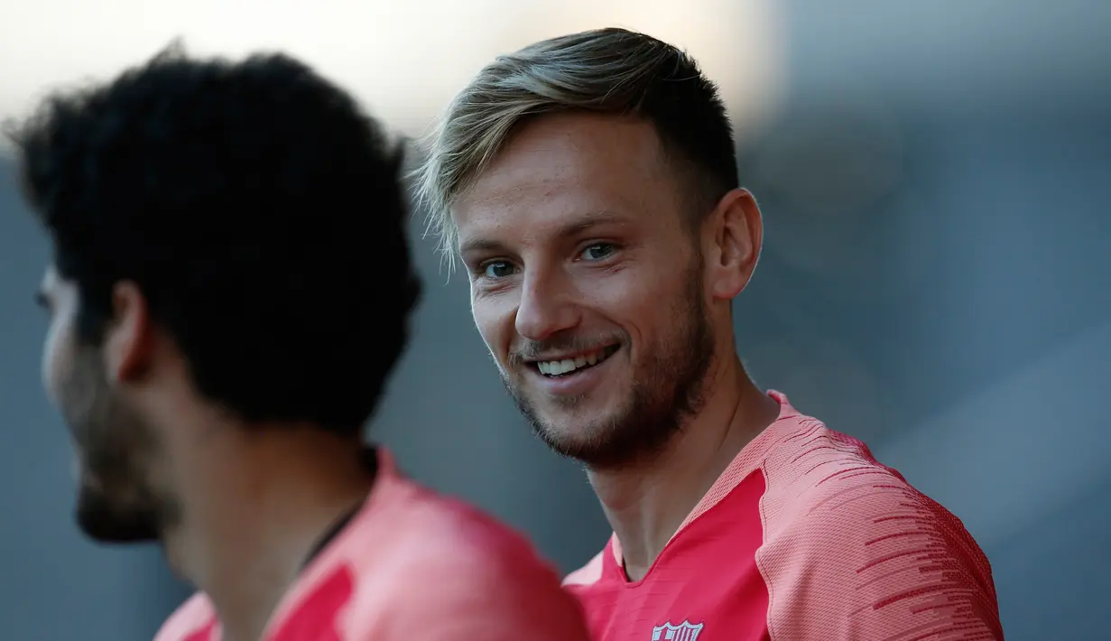 Gelandang Barcelona, Ivan Rakitic tersenyum saat mengikuti sesi latihan di Barcelona, Spanyol (17/9). Barcelona akan bertanding melawan PSV Eindhoven pada grup B Liga Champions di Nou Camp. (AP Photo/Manu Fernandez)