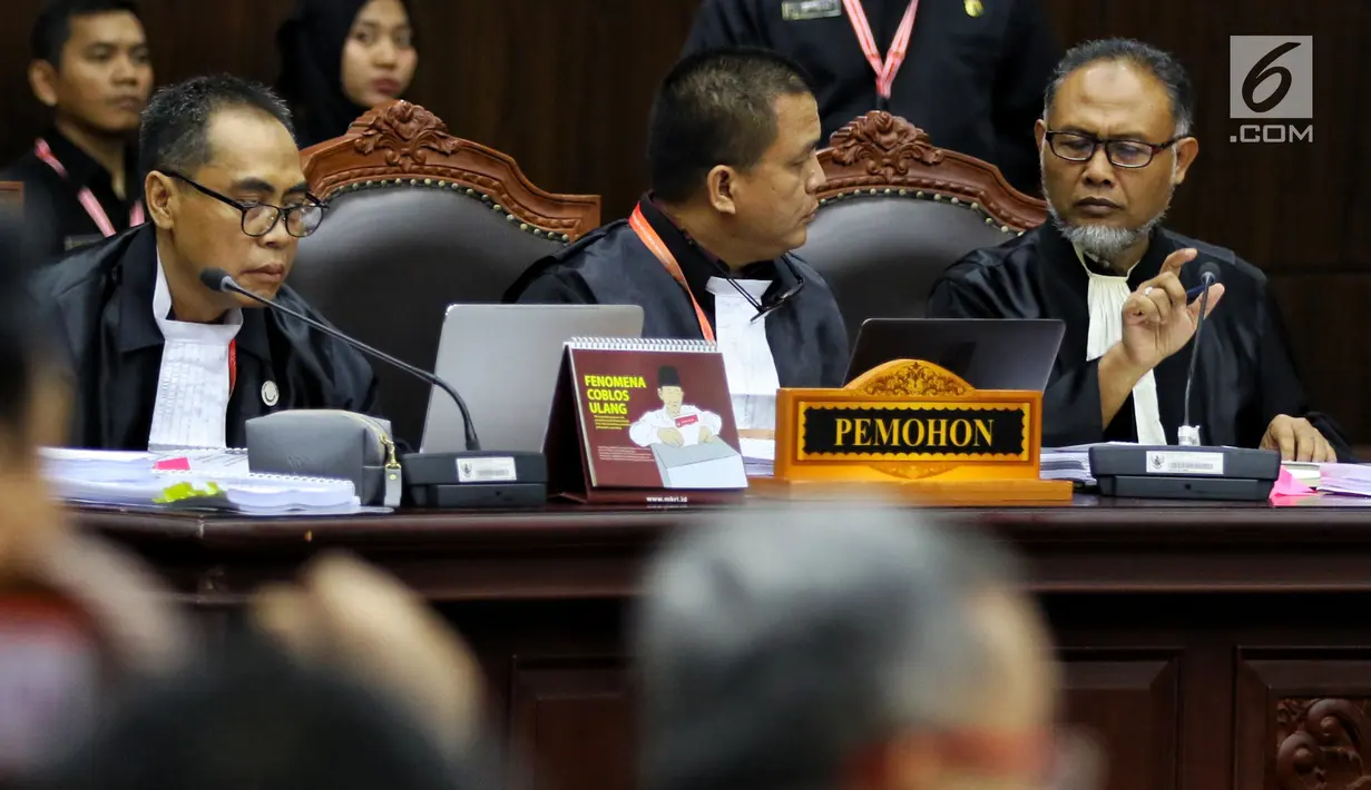 Kuasa hukum paslon nomor urut 02 selaku pemohon Bambang Widjojanto dan Denny Indrayana berdiskusi disela sidang perdana sengketa Pilpres 2019 di Gedung Mahkamah Konstitusi, Jumat (14/6/2019). Sidang tersebut dengan agenda pembacaan materi gugatan dari pemohon. (Lputan6.com/Johan Tallo)