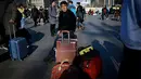 Seorang pria menunggu jadwal keberangkatan kereta di luar stasiun kereta api Beijing di ibu kota China, Senin (21/1). Sebagian warga China yang tinggal di kota-kota besar mulai mudik untuk merayakan tahun baru Imlek bersama keluarga. (WANG ZHAO/AFP)