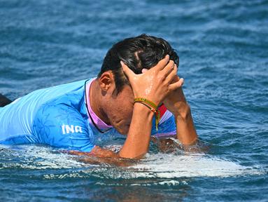 Ekspresi atlet selancar putra Indonesia, Rio Waida, setelah mengalami kekalahan pada babak kedua Olimpiade Paris 2024 di Teahupo'o, Tahiti, Kepulauan Polinesia, Prancis, pada Senin (29/7/2024). (AFP/Jerome Brouillet)