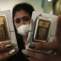 Pramuniaga menunjukkan emas batangan PT Aneka Tambang (Antam) Tbk di sebuah gerai emas, Jakarta, Senin (18/1/2021). Harga emas Antam kembali susut Rp 4.000 per gram di awal pekan. (Liputan6.com/Johan Tallo)