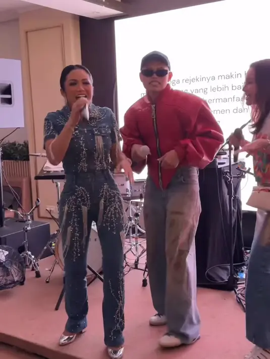 Krisdayanti hadir dengan setelan denim dari atasan lengan pendek berkantong dipadukan celana panjang. Setelan denim ini juga dihiasi payet silver. [@marlenehariman]