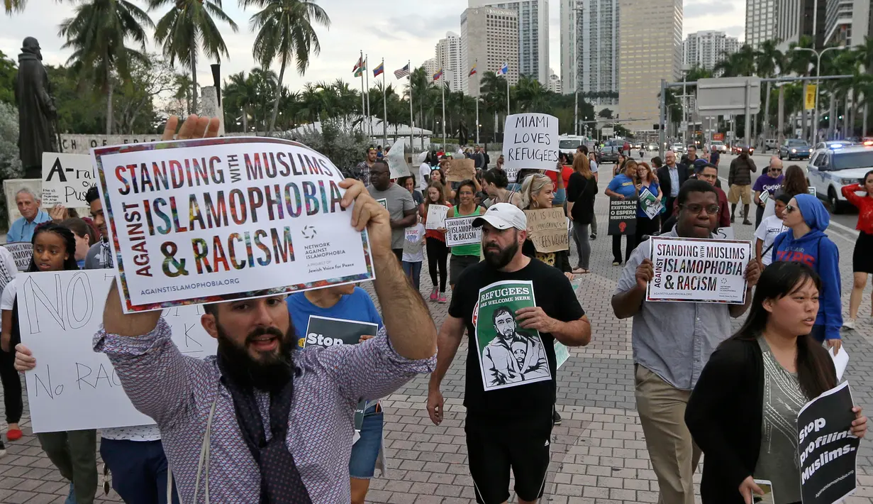 Pengunjuk rasa menolak kebijakan Trump yang membatasi imigrasi dari beberapa negara Timur Tengah dan Afrika masuk ke AS, Miami, Kamis (26/1). (AP Photo / Alan Diaz)