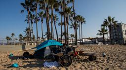Seorang pria tunawisma bermain drum pada pagi hari di Venesia, California, Amerika Serikat, 12 Agustus 2021. (Apu GOMES/AFP)