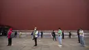 Para pengunjung mengenakan masker dan menjaga jarak aman saat akan memasuki Kota Terlarang, Beijing, China, Jumat (1/5/2020). Kota Terlarang kembali dibuka setelah ditutup lebih dari tiga bulan karena pandemi virus corona COVID-19. (AP Photo/Mark Schiefelbein)