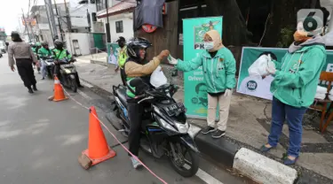 Ojek online (ojol) menerima bantuan berupa bingkisan makan siang dan hand sanitizer di kawasan Jalan Raden Saleh, Jakarta, Selasa (7/3/2020). Bantuan dari DPP PKB guna meringankan beban ojol yang sepi orderan akibat lesunya perekonomian selama pandemi corona Covid-19. (Liputan6.com/Fery Pradolo)