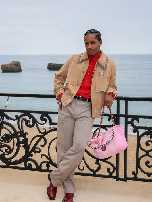  jaket suede beige dipadu kemeja merah bold dan celana tailored, dilengkapi tas Chanel pink statement yang playful sekaligus sentimental. [Dok/Chanel].