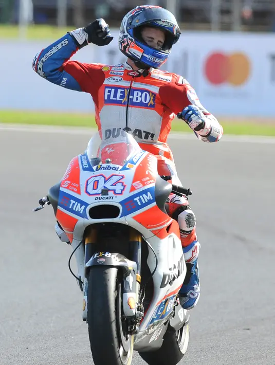Pembalap Tim Ducati Corse, Andrea Dovizioso melakukan selebrasi di atas motornya usai keluar sebagai yang tercepat dalam GP Inggris di Sirkuit Silverstone, Minggu (27/8). Dovizioso finis dengan catatan waktu 40 menit 45,486 detik. (AP Photo/Rui Vieira)