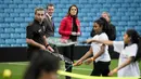 Kate Middleton mengamati kegiatan anak-anak peserta program mentoring Coach Core di markas klub sepakbola Aston Villa, Birmingham, Rabu (22/11). Perut Kate yang mulai membuncit terlihat dari balik jaket ski merahnya yang tebal. (AP Photo/Pool)