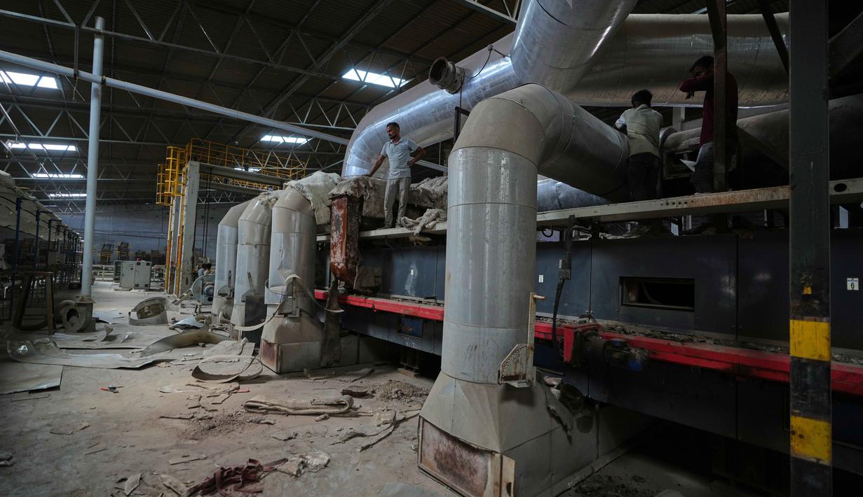 Para pekerja tiba untuk melakukan pekerjaan pemeliharaan di sebuah pabrik keramik yang tutup di Morbi, negara bagian Gujarat, India, Rabu 8 April 2026. Industri keramik di Morbi, negara bagian Gujarat, India, menghadapi krisis akibat kekurangan 
pasokan bahan bakar. (AP Photo/Ajit Solanki)