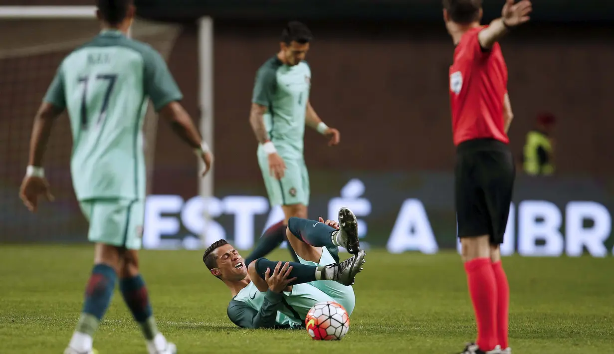 Pemain  Portugal, Cristiano Ronaldo meringis kesakitan saat dijatuhkan pemain Belgia pada laga persahabatan di Stadion Magalhaes Pessoa, Leiria, Portugal, Rabu (30/3/2016) dini hari WIB. (REUTERS/Rafael Marchante)