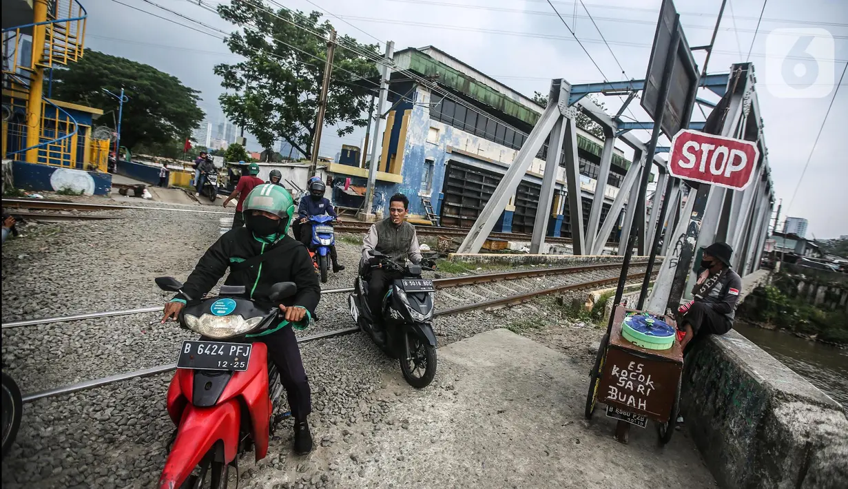 Kendaraan roda dua tetap melintas walaupun sudah ditutup di perlintasan kereta api di Tanah Abang-Palmerah Jakarta, Jumat (24/6/2022). Keenam perlintasan liar yang rawan kecelakaan dan ditutup Km 22+5/6 petak jalan Cakung-Kranji, Km 8+2/3 petak jalan Tanahabang-Palmerah, dan Km 41+2/3 petak jalan Citayam-Bojonggede. (Liputan6.com/Faizal Fanani)