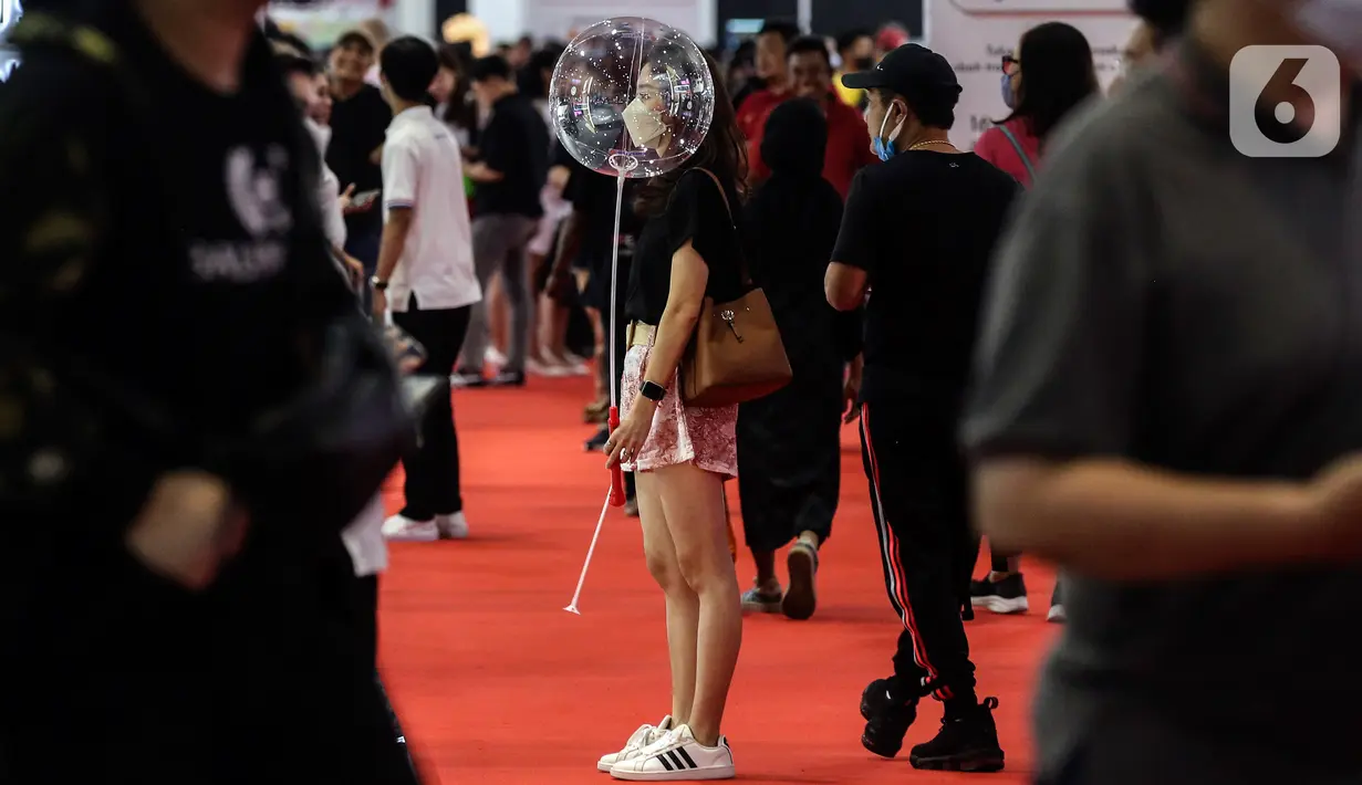 Seorang wanita membawa balon pada hari kedua pameran Indonesia International Motor Show (IIMS) 2023 di JIExpo Kemayoran, Jakarta Pusat, Jumat (17/2/2023). IIMS 2023 yang berlangsung hingga 26 Februari mengangkat tema "Bringing Opportunity for Otomotive Society Together" (BOOST) dan menghadirkan sekitar 40 merek otomotif dengan menampilkan produk dan konsep terbaru. (Liputan6.com/Johan Tallo)