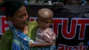 Di antara puluhan pengunjuk rasa, tampak seorang ibu menggendong anaknya yang masih kecil, Jakarta, (22/9/14). (Liputan6.com/Faizal Fanani)