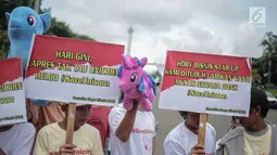 Puluhan massa yang tergabung dalam Komunitas Blogger Milenial (KBM) menggelar aksi #SaveUnicorn di Jakarta, Selasa (19/2). Massa membawa sejumlah spanduk dan boneka unicorn. (Liputan6.com/Faizal Fanani)