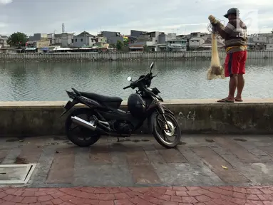 Warga yang hendak menjala ikan memarkirkan kendaraannya di trotoar Danau Sunter, Jakarta, Jumat (19/1). Meskipun telah dibenahi, masih banyak warga yang memarkirkan sepeda motornya di trotoar tersebut. (Liputan6.com/Immanuel Antonius)