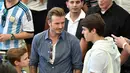Suami Victoria Beckham itu (tengah) tampil santai dengan mengenakan kaus putih berpadu kemeja denim di stadion Maracana, Brasil, Senin (14/7/14). (AFP PHOTO/Nelson Almeida)