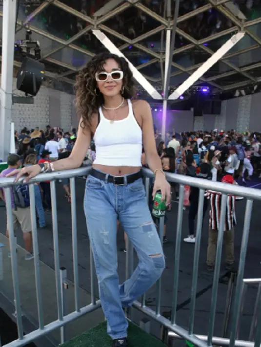 <p>Ashley Madekwe terlihat menjaga tampilannya tetap kasual dengan cropped baby tank, high waisted mom jeans, dan sunnies putih. Foto: Bustle.</p>