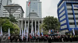 Personel kepolisian mengawal unjuk rasa ratusan buruh dari Konferederasi Serikat Pekerja Indonesia di depan Gedung MK Jakarta, Jumat (22/7). Mereka mengajukan berkas gugatan uji materi atas UU Pengampunan Pajak (Tax Amnesty). (Liputan6.com/Gempur M Surya)