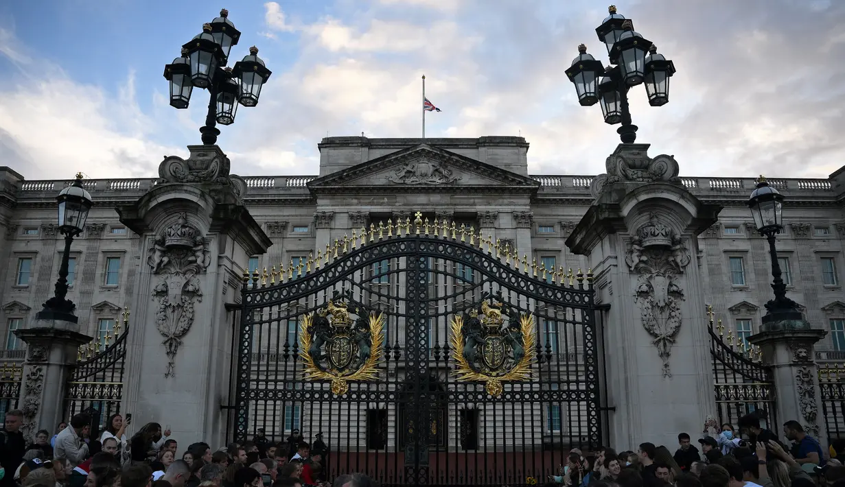 Sebuah bendera serikat berkibar setengah tiang di atas Istana Buckingham setelah pengumuman bahwa Ratu Elizabeth II telah meninggal, di pusat kota London pada 8 September 2022. Ratu Elizabeth II melampaui nenek buyutnya, Ratu Victoria sebagai pemimpin terlama Inggris. (Photo by Daniel LEAL / AFP)
