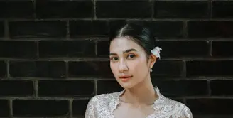 Mikha Tambayong tampil mempesona dalam balutan kebaya Bali berwarna putih gading dengan detail renda yang indah. [@miktambayong].