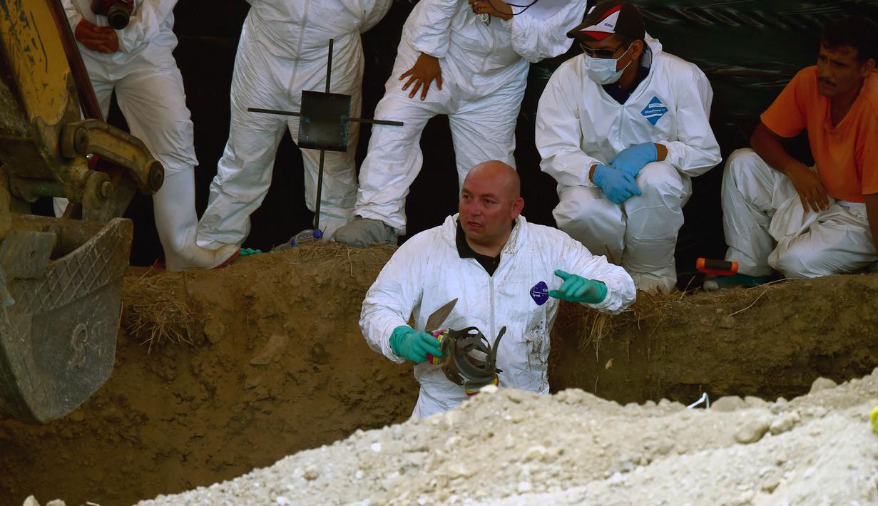 Petugas forensik saat melakukan penggalian kuburan massal di Tetelzingo, Morelos, Meksiko (23/5).Terdapat sedikitnya 116 mayat yang terkubur massal ditempat ini. (ALFREDO ESTRELLA / AFP)