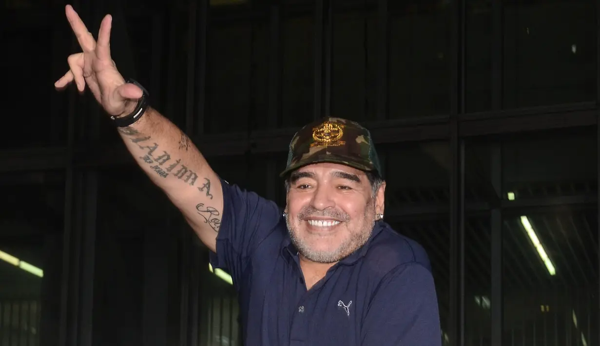 Legenda sepak bola, Diego Maradona, menyapa fans saat tiba di Bandara Netaji Subhas Chandra Bose, Kolkata, Minggu (10/12/2017). Kunjungan ini dilakukan pria asal Argentina itu dalam rangkaian liburan. (AFP/Stringer)