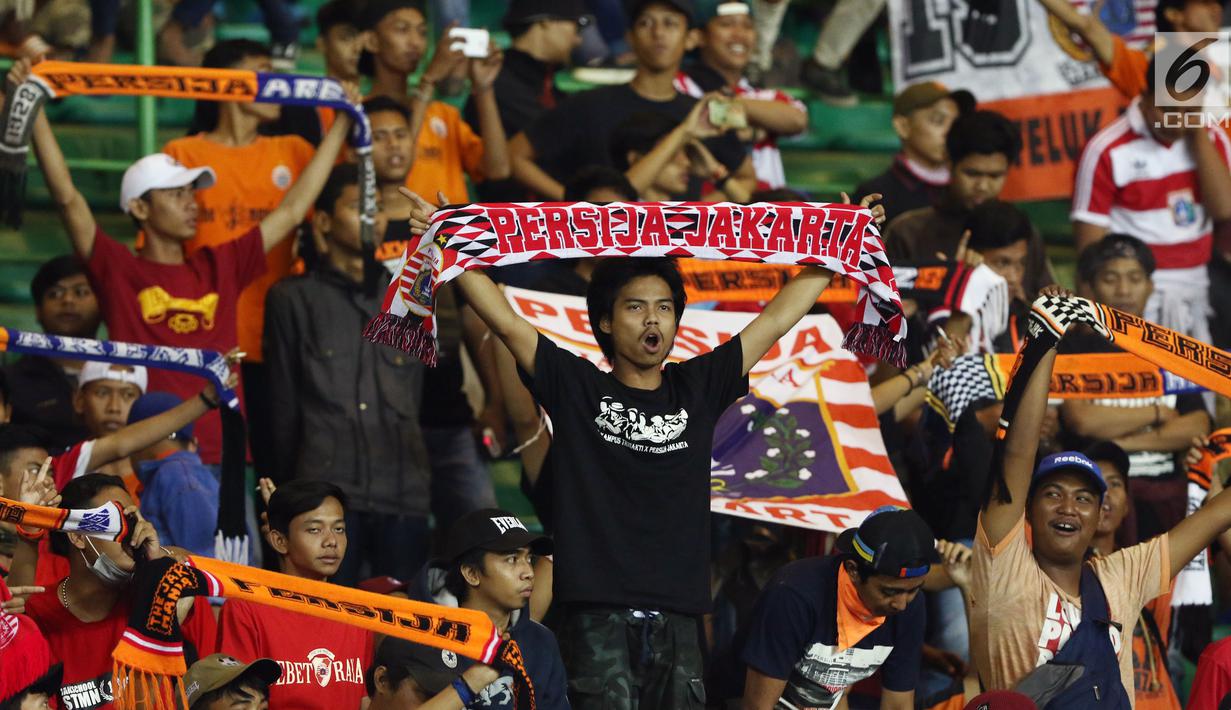 Suporter Persija membentangkan syal merayakan kemenangan tim Macan Kemayoran atas Perserui pada lanjutan Liga 1 Indonesia di Stadion Patriot Candrabhaga, Bekasi, Selasa (13/6). Persija menang telak 3-0 atas perserui. (Liputan6.com/Helmi Fithriansyah)