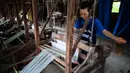 Seorang perempuan menenun kain di sebuah bengkel kerja di Desa Etnis Dong Fengdeng di Wilayah Rongjiang, Provinsi Guizhou, China pada 6 September 2020. Warga setempat memanfaatkan kondisi cuaca musim gugur yang mendukung untuk membuat kain tradisional kelompok etnis Dong. (Xinhua/Liu Xu)