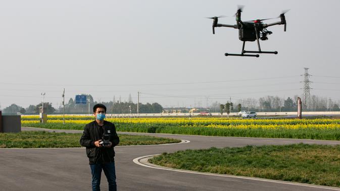 Seorang teknisi mengoperasikan sebuah drone pertanian untuk memotret beberapa gambar multispektral tanaman di sebuah lahan pertanian di Wilayah Dayi, Provinsi Sichuan, China, 24 Februari 2020. (Xinhua/Li Mengxin)