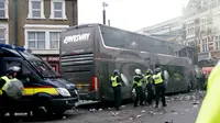 Sejumlah petugas kepolisian berjaga di sekitar bus skuat Manchester United yang diserang suporter West Ham United di depan Stadion Boleyn Ground, London, Selasa (10/5). Kejadian itu membuat kick-off laga kedua tim menjadi tertunda. (Reuters/Eddie Keogh)