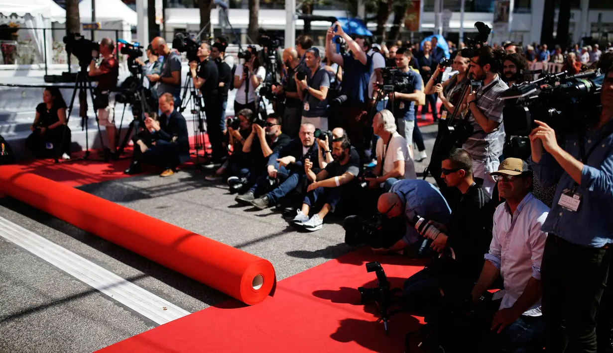 Fotografer menunggu pemasangan karpet merah di depan pintu masuk utama jelang upacara pembukaan Festival Film Cannes 2019 di Cannes, Prancis, Selasa (14/5/2019). Festival Film Cannes tahun ini memasuki gelaran ke-72. (REUTERS/Stephane Mahe)