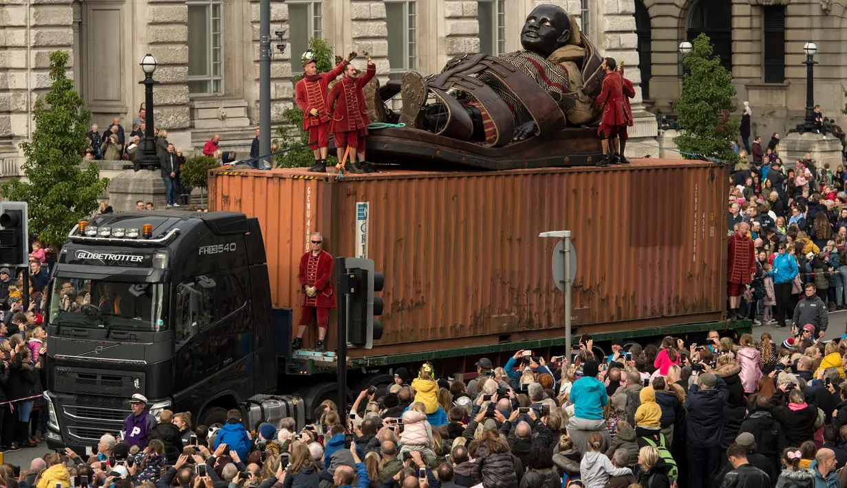 Kerumuman warga melihat boneka raksasa Little Boy Giant diangkut melewati dermaga di Liverpool, Inggris, Minggu (7/10). Boneka tersebut merupakan karya dari kelompok teater jalanan Prancis, Royal de Luxe yang berjudul: Liverpool's Dream (OLI SCARFF/AFP)