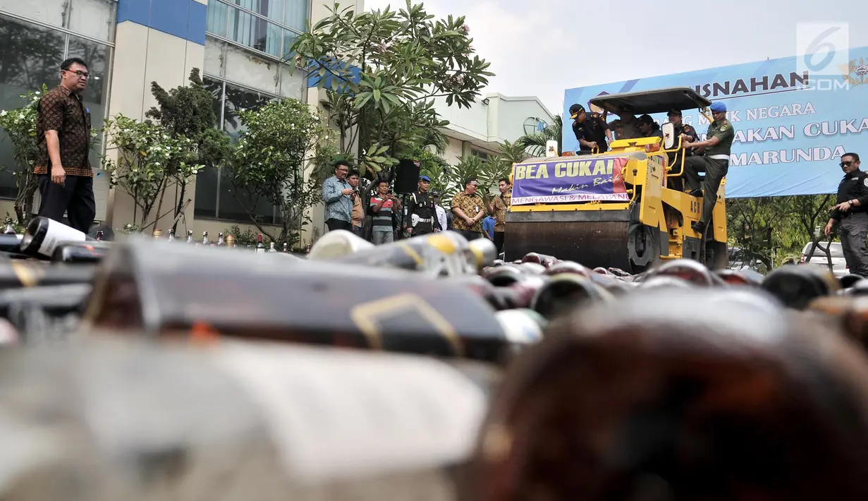 Dirjen Bea Cuka Heru Pambudi beserta jajaran menaiki buldozer saat memusnahkan miras dan rokok ilegal di Kantor Bea Cukai Marunda, Jakarta, Selasa (2/10). Kemenkeu melalui Bea Cukai memusnahkan 2.231.935 batang rokok ilegal. (Merdeka.com/Iqbal Nugroho)