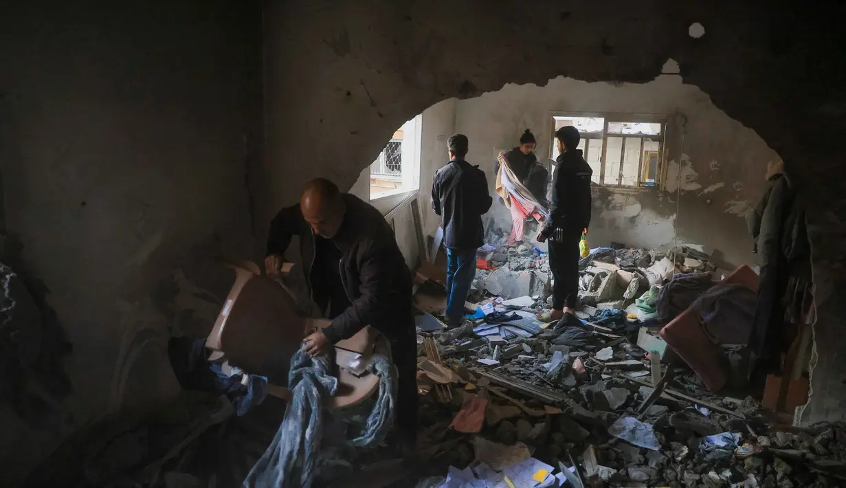 Pemerintah Palestina di Gaza melaporkan Israel melakukan sedikitnya 1.244 pelanggaran selama fase pertama gencatan senjata yang mulai berlaku pada 10 Oktober 2025. Tampak dalam foto, warga Palestina menyelamatkan barang-barang dari sebuah rumah setelah serangan militer Israel terhadap rumah keluarga al-Houli, di mana empat orang dilaporkan tewas, di sebelah barat Deir al-Balah, di Jalur Gaza tengah pada Jumat 16 Januari 2026. (BASHAR TALEB/AFP)