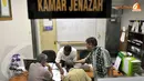 Keluarga Benget sedang mengurus administrasi dengan petugas kamar jenazah RSCM. (Liputan6.com/Danu Baharuddin)