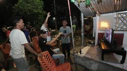 Sejumlah warga meluapkan kebahagiaan setelah Timnas Indonsia mengalahkan Bahrain dalam pertandingan Grup C putaran ketiga Kualifikasi Piala Dunia 2026 zona Asia di kawasan Menteng Jaya, Jakarta, Selasa (25/5/2025). (Bola.com/M Iqbal Ichsan)