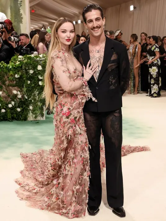 Dove Cameron dan Damiano David kenakan busana semi transparan dari Diesel. Dove Cameron kenakan gaun penuh bunga sedangkan Damiano David kenakan setelan jas semi transparan hitam [@dovecameron]